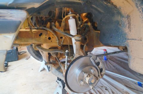 1998 Ford Ranger - Close-up view of the front suspension and brake components, possibly undergoing maintenance or repair.