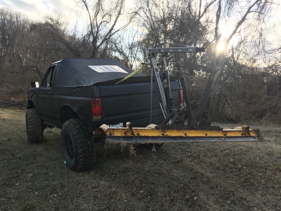 Black lifted pickup truck with tow hitch attachment, rear view