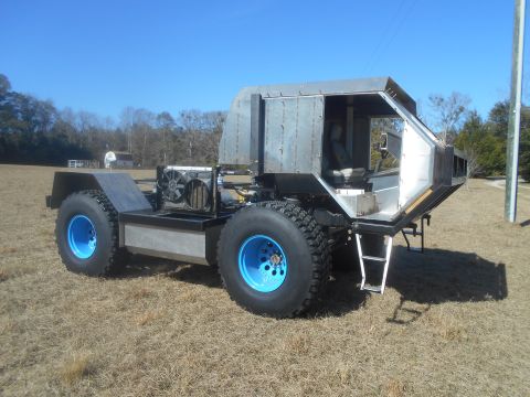 1992 Ford Bronco - This custom-built vehicle has large off-road tires and a unique metal cab structure.