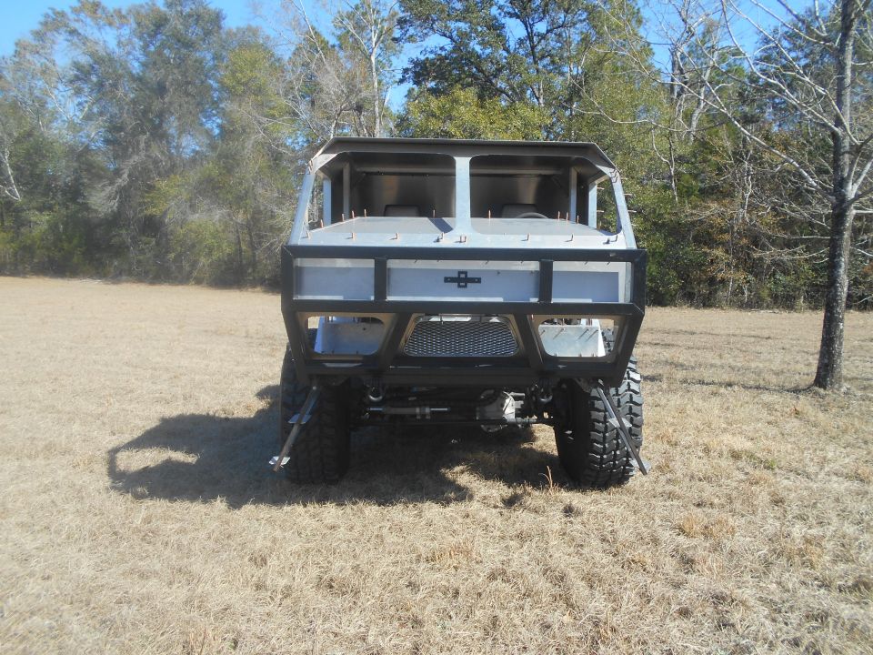 custom off-road vehicle, rear view, with large tires and roll cage