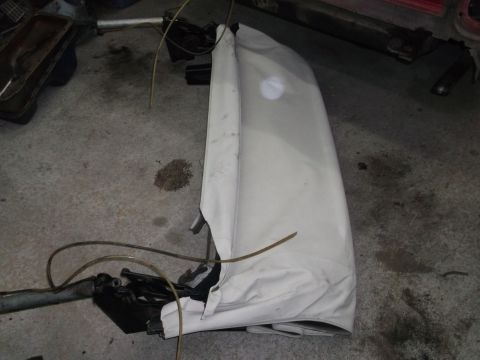 1967 Ford Galaxie - A white convertible top is folded and covered, lying on a concrete floor.