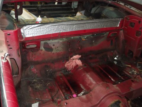 1967 Ford Galaxie - The interior of a classic car is shown stripped down for restoration, revealing the bare metal floor and insulation.