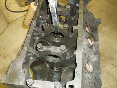 1969 Ford Mustang - Close-up of an engine block's internal components, with a tool engaged.
