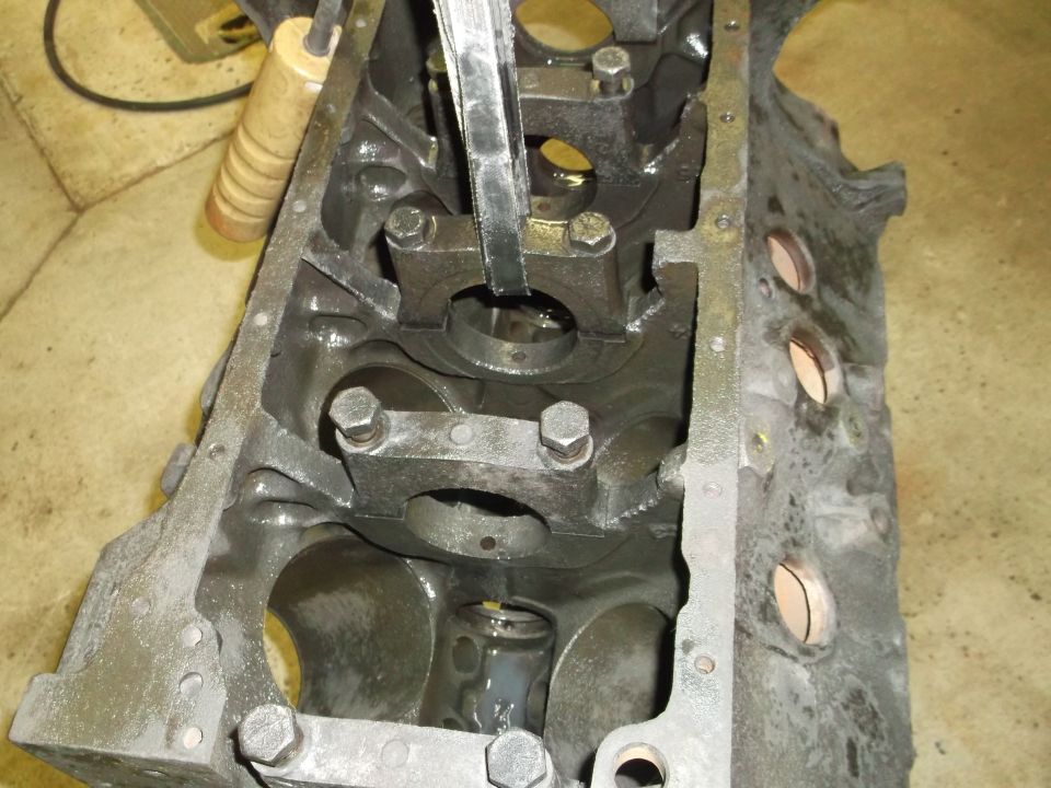 Engine block interior with a tool inserted into a bearing cap