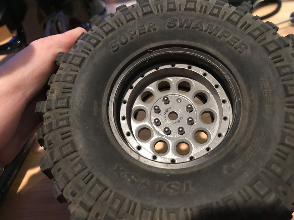 Close-up of a Super Swamper tire with a silver beadlock wheel.