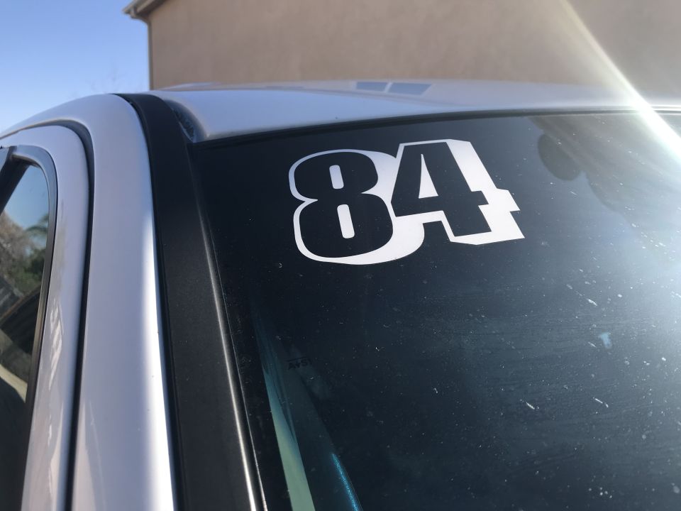 Number 84 racing decal on a vehicle windshield