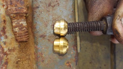 1988 Ford Bronco - A close-up shot shows two brass fittings being threaded onto a rusty bolt. A person's fingers are visible, holding the bolt and the fitting…