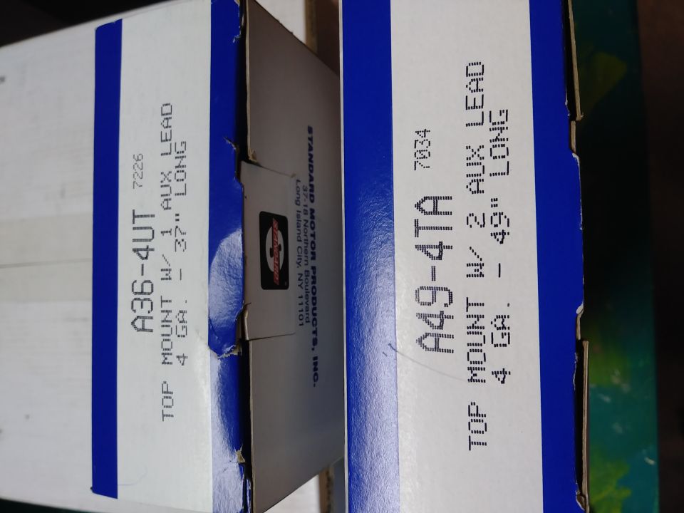 Two boxes of automotive parts, labeled with part numbers and descriptions.