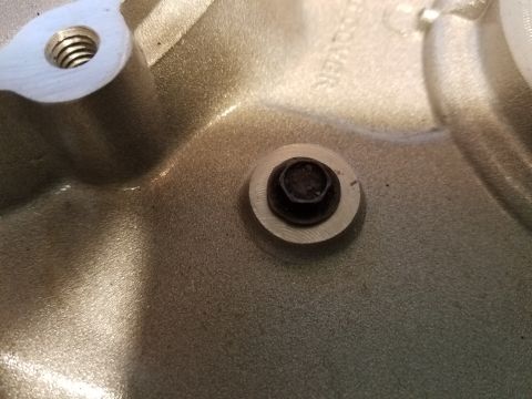 1976 Ford Ranchero - A close-up shot shows a bolt with a washer installed in a textured, metallic surface. Another threaded hole is visible in the upper left co…