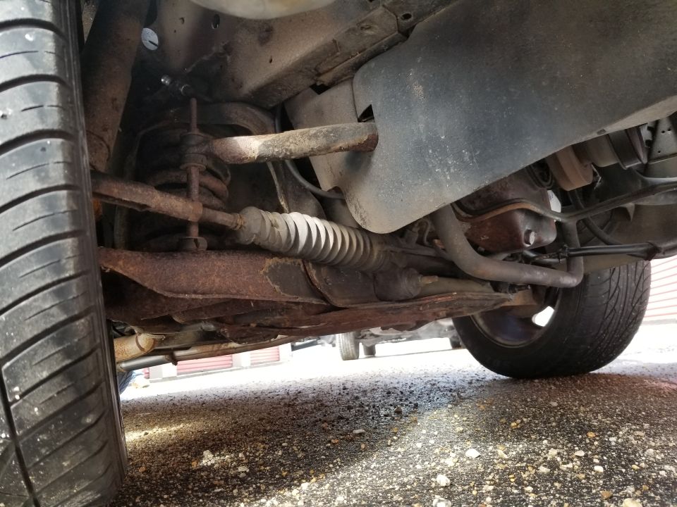 Photo of a rusty car undercarriage and rear suspension