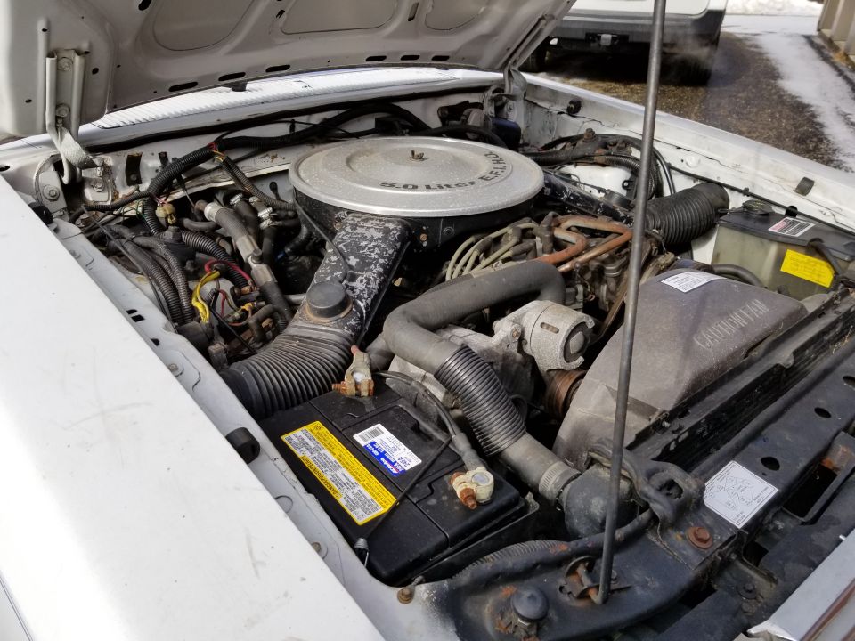 Photo of an engine bay with air cleaner and battery