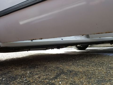 2001 Ford Crown Victoria - Photograph of a vehicle's lower rocker panel and underbody on gravel; not a technical document.