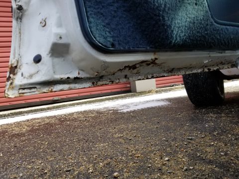 2001 Ford Crown Victoria - Photograph of a rusty door sill and lower door edge on a parked car; not a technical document.