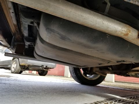 2001 Ford Crown Victoria - Photograph of a vehicle underbody showing exhaust pipe and floor pan; not a technical document.