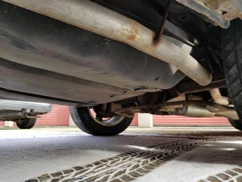 2001 Ford Crown Victoria - Photograph of a vehicle underbody exhaust pipe and rear wheel; not a technical document.
