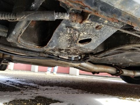 2001 Ford Crown Victoria - Photograph of a vehicle underbody showing frame and exhaust components; not a technical document.
