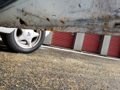 2001 Ford Crown Victoria - Photograph of a car's alloy wheel and rusted rocker panel; not a technical document.