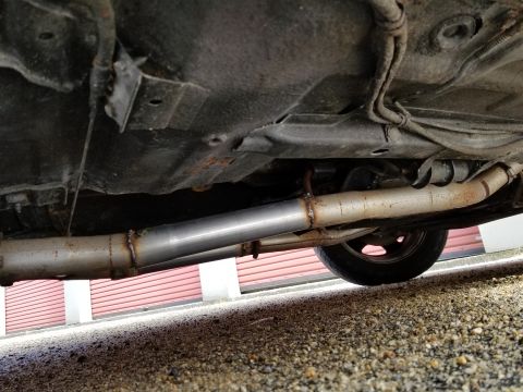2001 Ford Crown Victoria - Photograph of a vehicle underbody with exhaust pipe and floor pan; not a technical document.