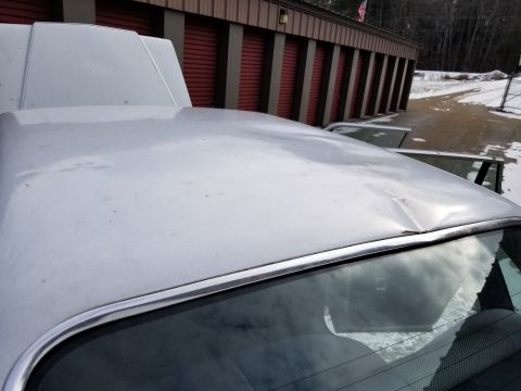 2001 Ford Crown Victoria - Photo of the roof and windshield area of a white sedan, not a technical document.