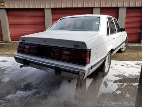 2001 Ford Crown Victoria - Photo of the rear three-quarter of a white Ford LTD sedan, not a technical document.