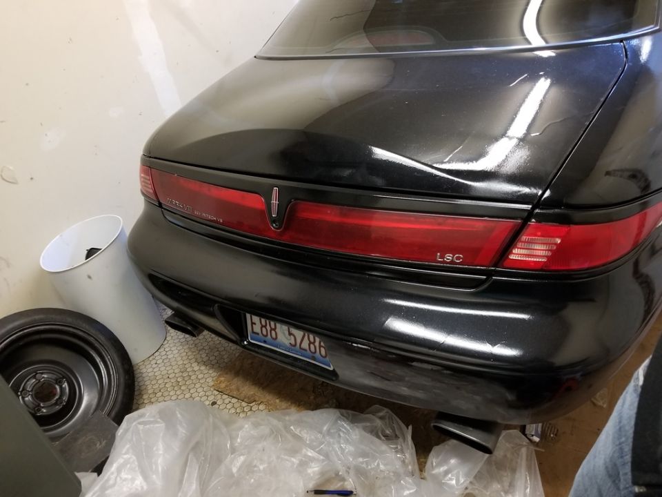 Black 1998 Lincoln Mark VIII rear view, parked indoors.