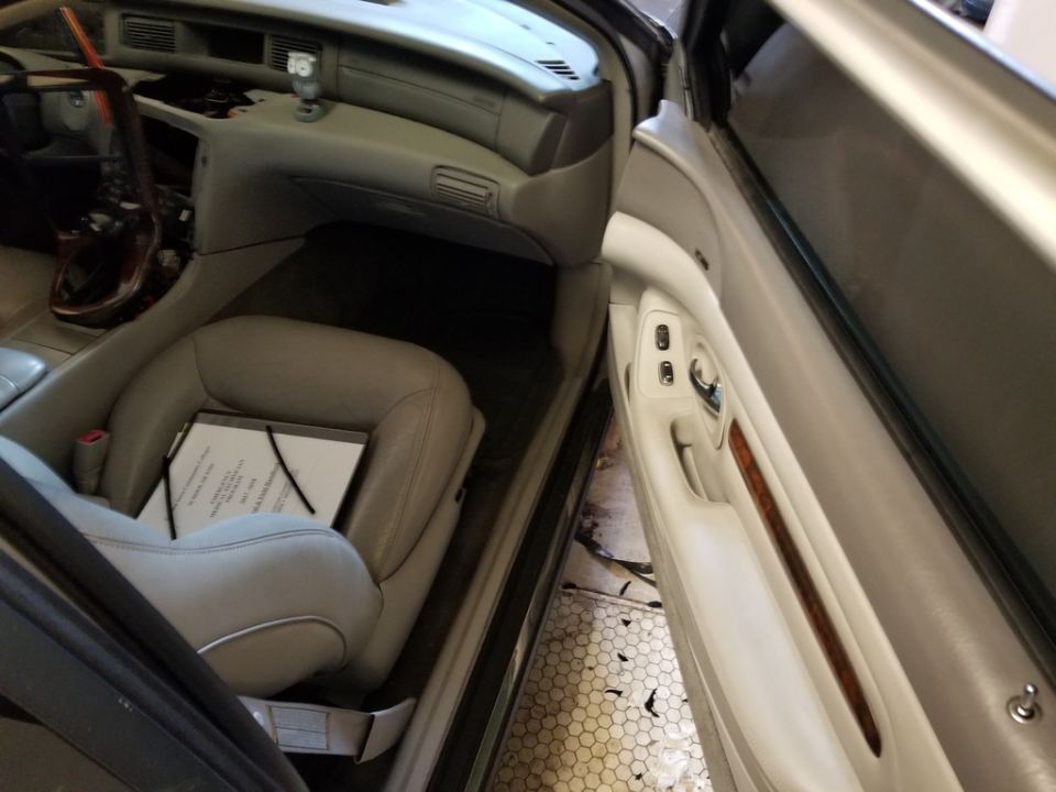 Interior of a car, driver's seat with document, open driver's door.
