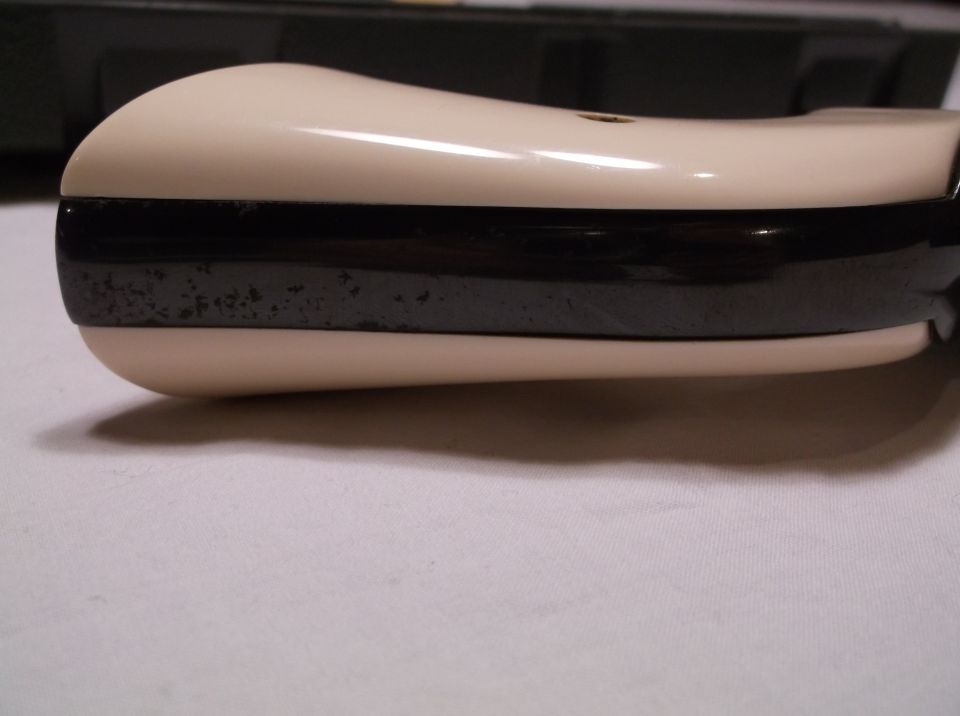 Cream-colored grip with black stripe detail showing wear.