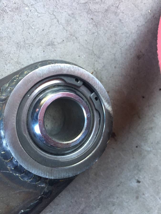 Close-up of a spherical bearing in a metal housing.