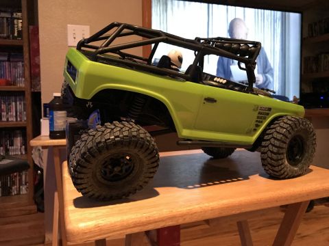 1989 Ford Bronco - RC rock crawler toy truck with a roll cage and aggressive tires sits on a table.