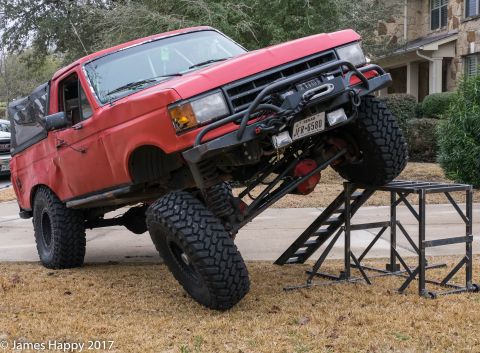 1989 Ford Bronco - Modified 1989 Ford Bronco with extreme suspension lift on metal ramps.