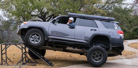 1989 Ford Bronco - SUV is positioned on a ramp, with one wheel elevated.