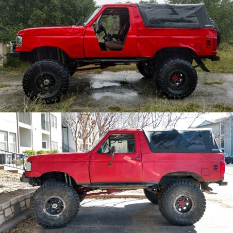 1989 Ford Bronco - This lifted red Bronco has a soft top and a skull decal on the rear fender.