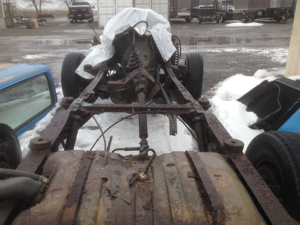 Rusted chassis and drivetrain with fuel tank visible