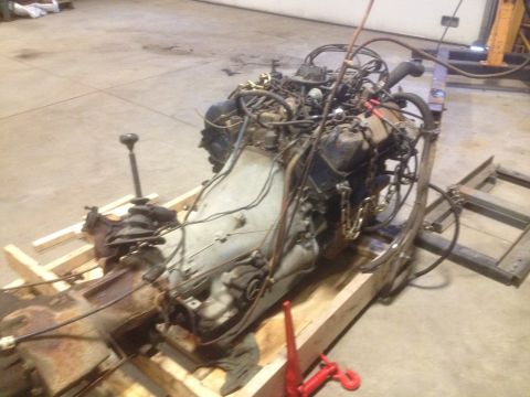 1979 Ford Bronco - A disassembled engine and transmission unit is prepared for transport or storage in a workshop setting.