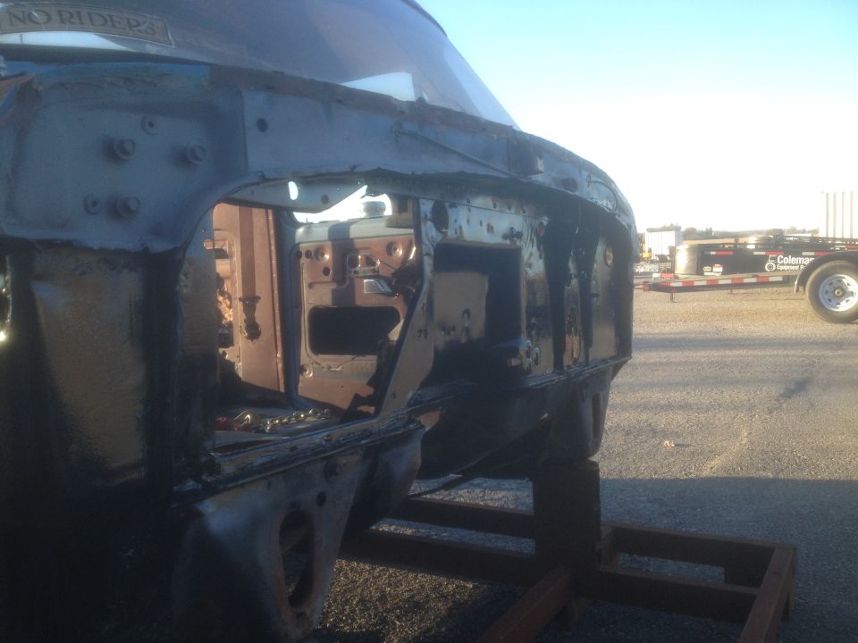 1979 Ford Bronco frame showing rusted interior and body panels, supported by wooden blocks