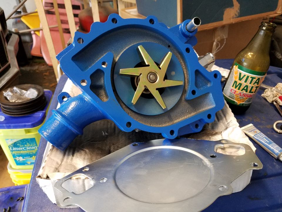 Blue water pump with gold impeller and gasket. Bottle of Vita Malt Classic visible
