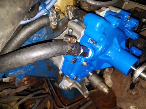 1976 Ford Ranchero - Close-up view of a newly painted blue water pump installed on an engine, with black hoses connected.