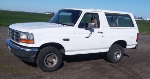 1993 Ford Bronco - This white Ford Bronco is shown from the side, parked outdoors on a sunny day.