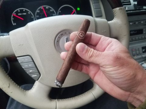 2018 Ford Bronco - A hand holds a cigar in front of the steering wheel and dashboard of a Lincoln vehicle.