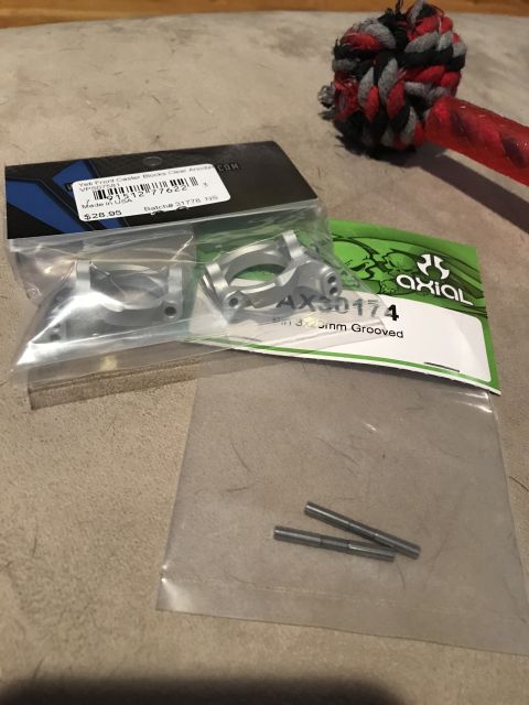 1989 Ford Bronco - Two sets of RC car parts, one labeled Axial AX30174, are laid out on a textured surface.