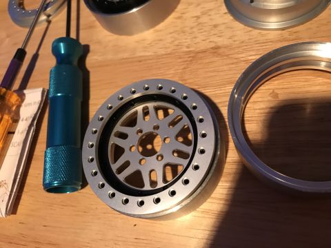 1989 Ford Bronco - Model car wheel assembly and tools laid out on a wooden surface.