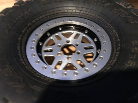 1989 Ford Bronco - A detailed view of an aftermarket off-road wheel and tire assembly, showing the intricate spoke design and tire sidewall markings.