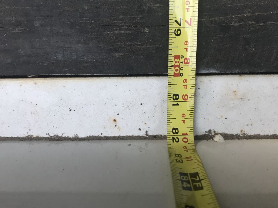 Yellow measuring tape showing measurements from 79 to 84 inches against a dark and white surface