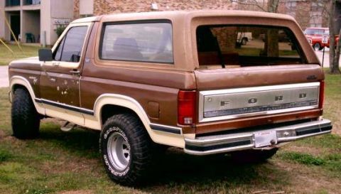 1980 Ford Bronco - This 1980 Ford Bronco is shown from the rear 3/4 angle, a brown and tan paint scheme and a chrome tailgate insert.