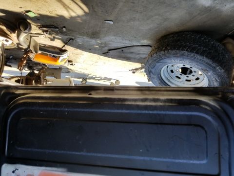 1967 Ford Bronco - The front fender and wheel of a black vehicle are visible, with parts scattered around. The registry claims it is a 1967 Ford Bronco.
