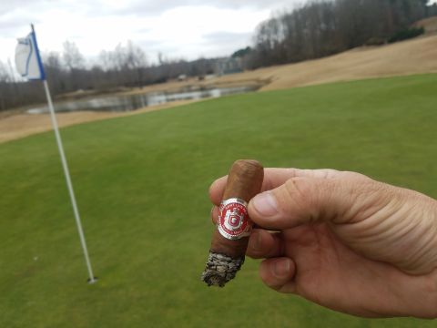 2018 Ford Bronco - Enjoying a cigar on the golf course with a pond and flag in view.