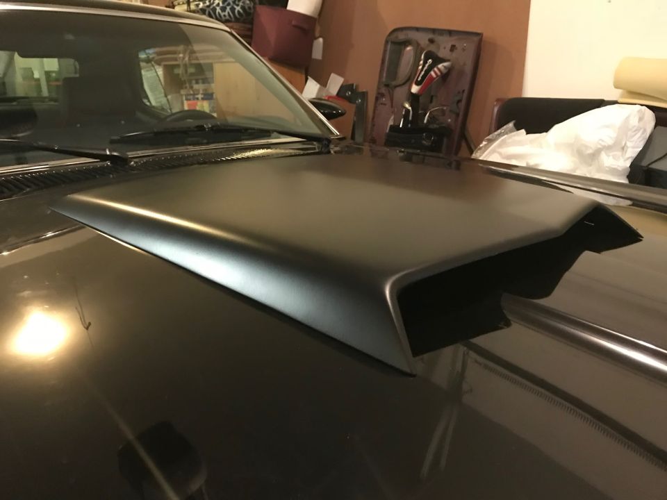 Black 1969 Mercury Cougar with a matte black hood scoop, viewed from the front