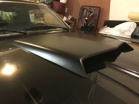 1969 Mercury Cougar - A black hood scoop is installed on the hood of a dark-colored car, with a "SUPERMOTORS" watermark visible.