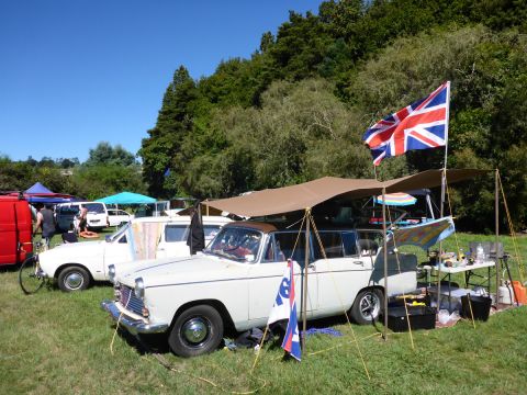 1962 MG B - A vintage station wagon is set up for camping with an awning and various gear, including a Union Jack flag.