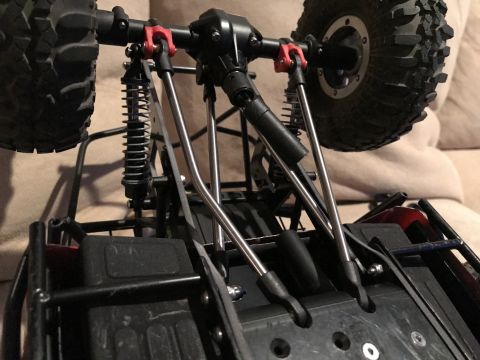1989 Ford Bronco - The underside of a remote control car chassis is visible, showing its suspension components and tires.